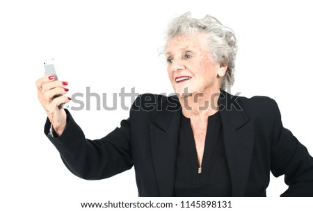 Old elegant business woman holding a mobile phone against a white background