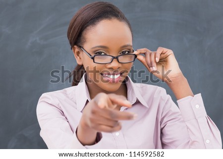 Teacher touching her glasses in a classroom