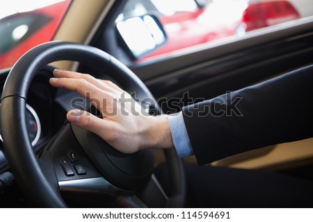 Man honking the horn in a car dealership Royalty-Free Stock Photo #114594691