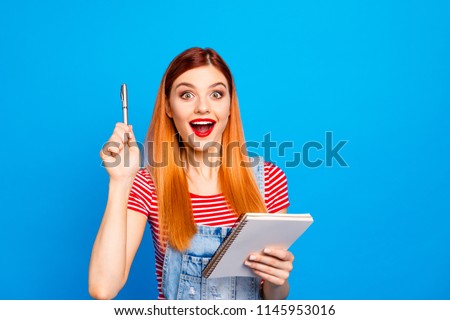 Young girl in red striped T-shirt and a bright lipstick on her lips came up with a great idea! Model teenager isolated on bright blue background