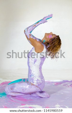 woman yogi covered with purple paint sitting on the picture and on top of the hand dripping paint