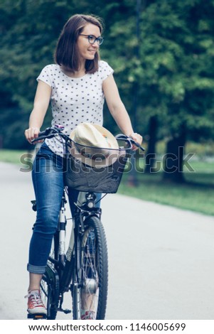 Happy young woman cycling outdoors in summer