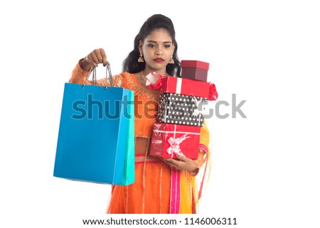 Beautiful woman carrying many shopping bags and gift Box on a white background.