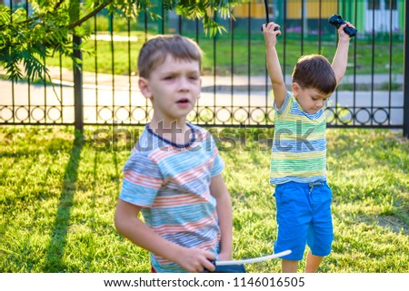 moment of winning. Two brother boy playing with modern spin top outdoors. Entertainment game for children. Top, triggered by a trigger.