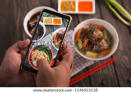 gesture of hand taking picture of delicious traditional food. blogger concept