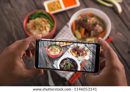 gesture of hand taking picture of delicious traditional food. blogger concept