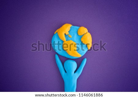 Person holding planet Earth. Person and planet Earth are made out of play clay (plasticine).