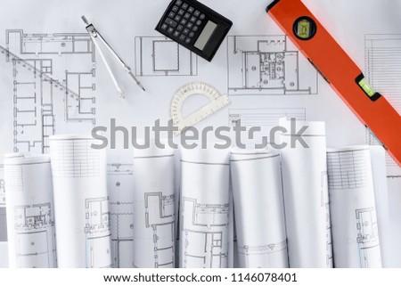 top view of architect blueprints, ruler, protractor, calculator, divider and spirit level 