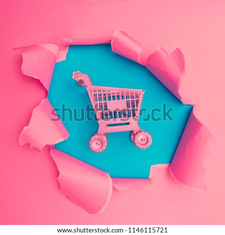 Shoping cart with vivid pink torn paper. Burst hole background. Minimal abstract colorful wallpaper concept.