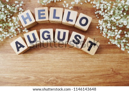 august alphabet letters on wooden background