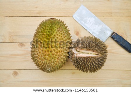 King of asian fruit at Malaysia. Green durian with knife fruit isolated on wooden background. Fruit, Food Concept.