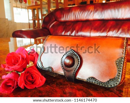 Stylish leather wallets in box on red mable  background