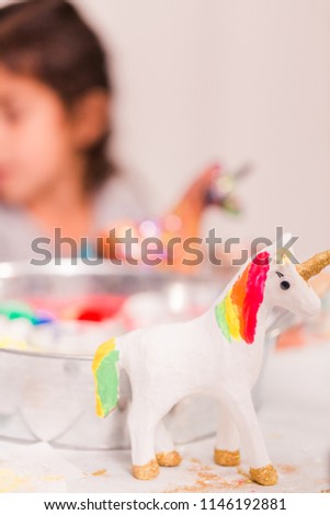Girls decorating their small paper mache unicorns figurines at the unicorn extravaganza party.