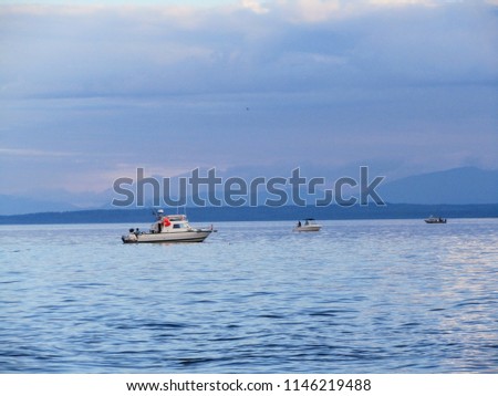 three small fishing boats trolling for salmon on the coast of Vancouver Island, British Columbia
