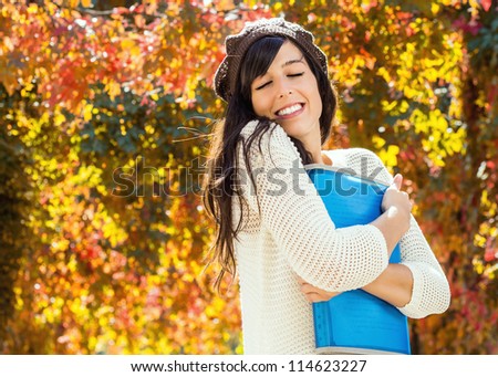 Charming brunette teen student on autumn background