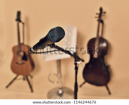 Microphone, classic guitar, sheet music, viola, music stand in a music studio