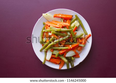 Home made food. Concept for a tasty and healthy meal. plate of salad in violet wooden background. Top view. Copy space.