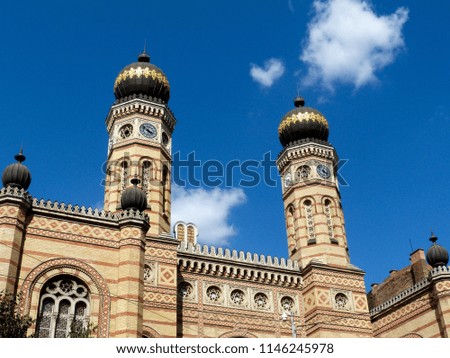 synagogue clock towers in diminishing perspective in Budapest, Hungary under blue sky with clouds. the Budapest synagogue is the largest in Europe. thousands  visit it daily, Budapest landmarks. 