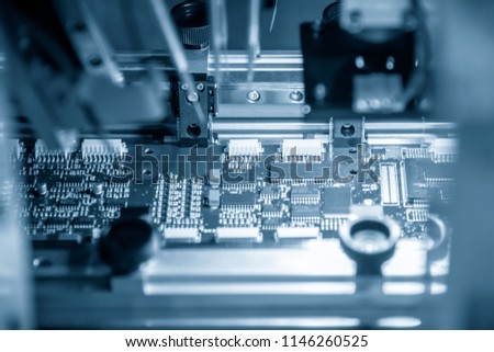 The assembly line of electronic board with microchip in the light blue scene.The electronics board production process.