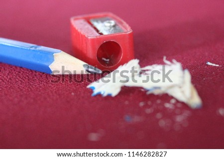 Blue pencil and red pencil sharpener On a red background
