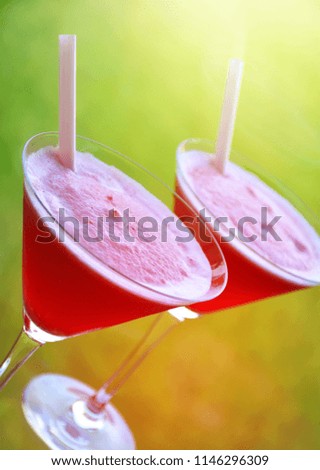 Cold red drink in martini shape cocktail glasses