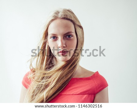 Deautiful blonde woman with long blonde fly hair natural portrait in pink dress female 