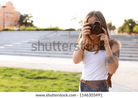 Young woman with camera on city street