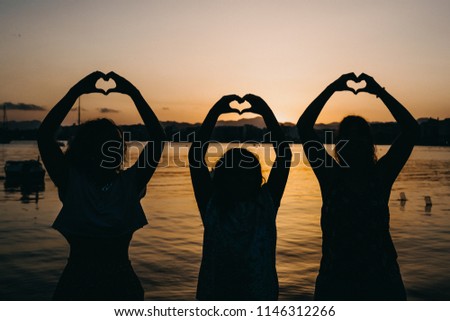 
Young people with funny and relaxed attitude, playing at the seashore on a beautiful summer sunset. Lifestyle.