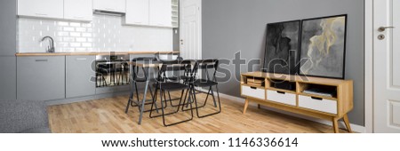Panorama of open plan kitchen with simple table and chairs