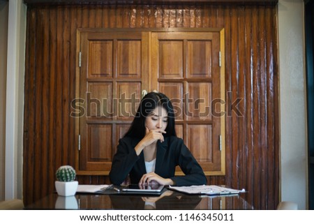 Asian business woman Check the documents in the office.