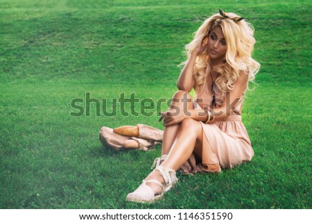 Rest in park, outdoor, people and leisure concept - beauty blonde alone young woman resting in the park