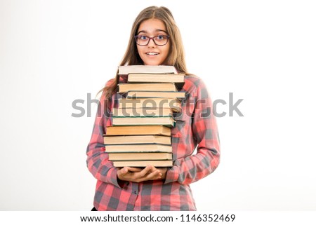 Girl with many books. A student holds a large stack of books. Ubcheba at school. Library. Beginning of studies at the Institute. Young girl with a book in glasses