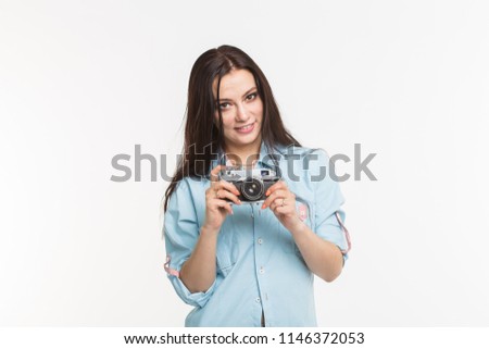 Photographer, hobby and people concept - Young brunette woman with retro camera on white background