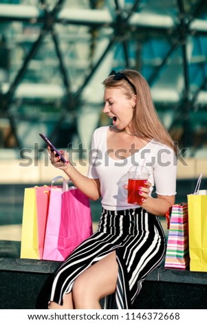 Happy girl with phone and colorful shopping bags. Quick and easy to order online, searching for discounts and sales