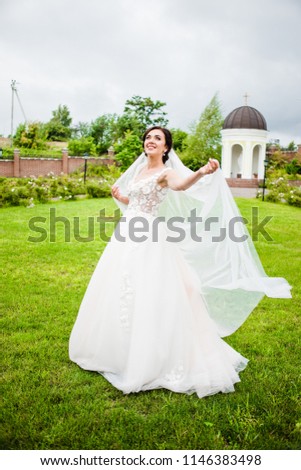 The bride in a white dress standing in the park
