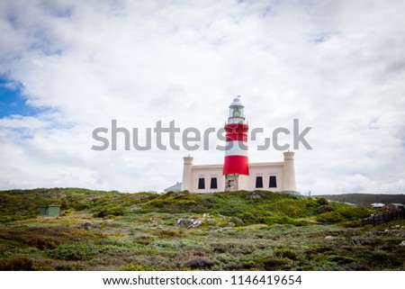 Beautiful lighthouse near Cape Agulhas, the southernmost point of Africa. Beautiful cloudy sky and gorgeous view, place where Indian and Atlantic Oceans meet