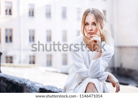 Pretty woman in white vintage dress sitting outdoor