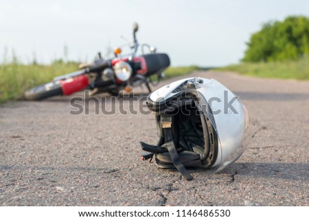 Photo of helmet and motorcycle on road, the concept of road accidents Royalty-Free Stock Photo #1146486530