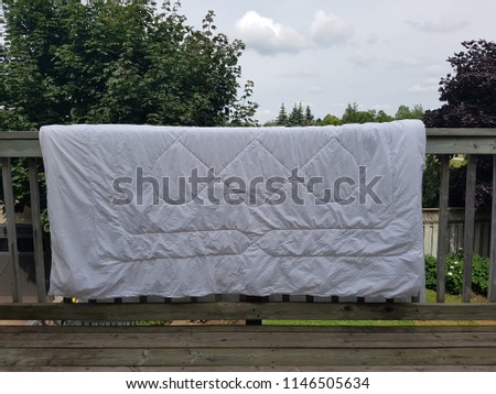 White duvet hang drying on the deck