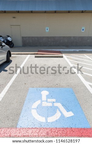 View of the parking sign for people with disabilities. Parking for disabled people and wheelchair symbols on the asphalt.