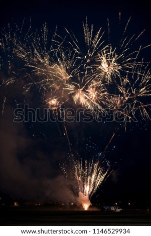 Multiple golden fireworks exploding in the sky