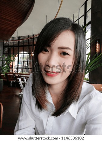 Beautiful young asian taking selfie pictures in coffee shop.