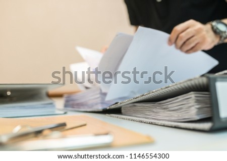 Office workers are arranging documents on the office desk.