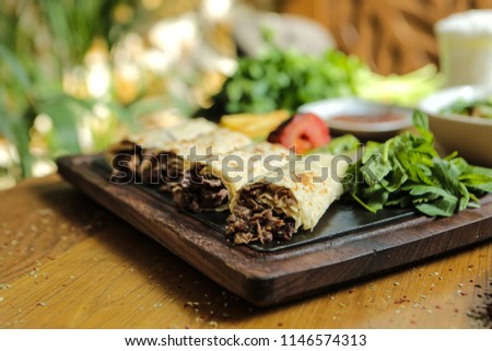 Steak roll turkish style served on a wood plate