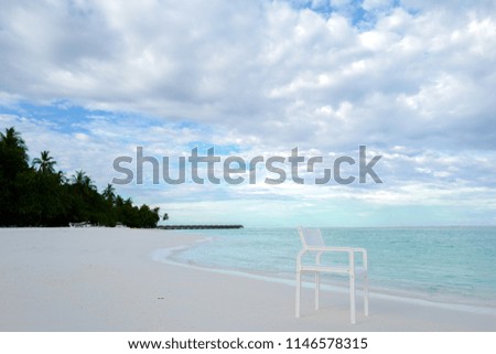 Summer concept , White chair on the beach white sand and turquoise sea color at maldives on the weekend holidays