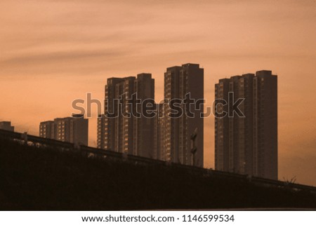 Sunrise over modern office buildings in business district at China. Skyline view of cityscape with sunlight and flare in warm light color tone. Construction business concept.