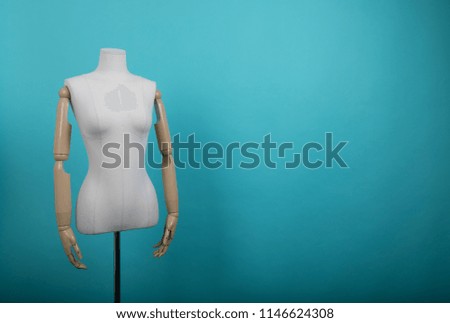 white mannequin stand at light wall.