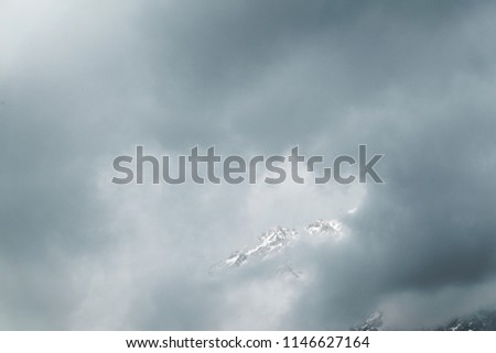 Snow-covered mountains of the Himalayas in the clouds at the height of