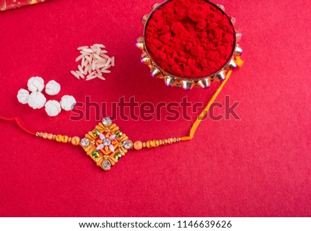 Raakhi with rice grains, kumkum and gift envelope for the sister given by brother on the occasion of Raksha Bandhan.A traditional Indian wrist band which is festival for brothers and sisters.