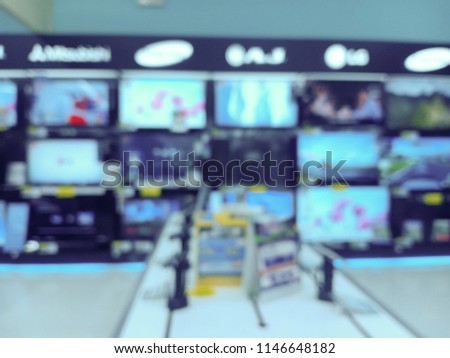 Blurred Row of Television on Shelf in Hypermarket, Supermarket or Electronic Home Appliance Shop. Abstract Blur Background.
